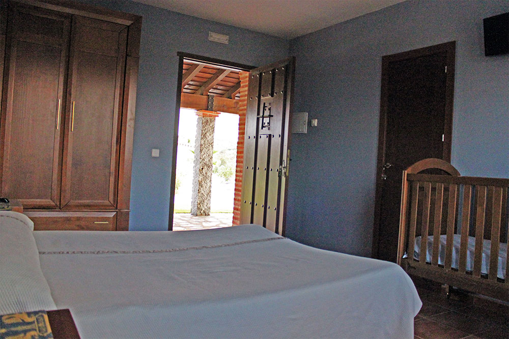 Habitación soble con cuna Casa Rural La Dehesilla de Melque